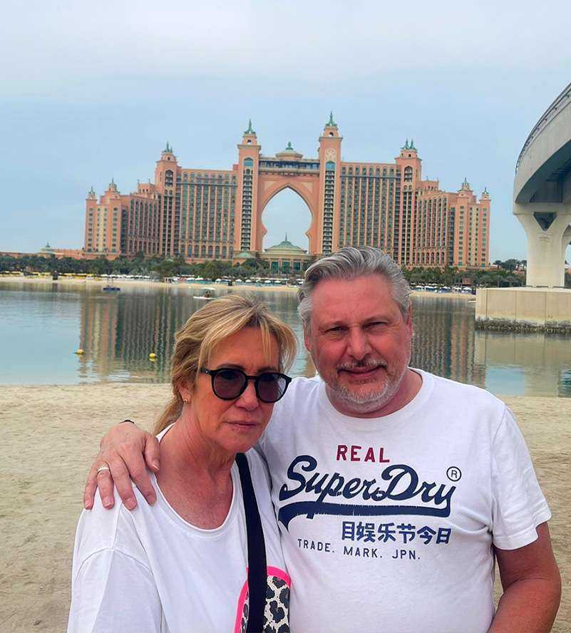 A couple enjoying the beach in front of a atlantis hotel, with the serene ocean as their backdrop