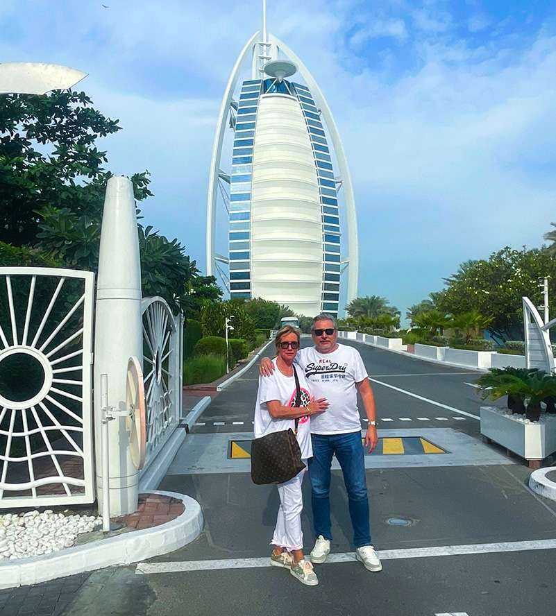 A couple posing in front of the iconic Burj Al Arab hotel, showcasing its grandeur and architectural beauty