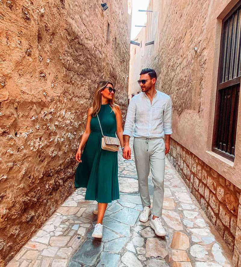 A couple strolling down a quaint alley in a charming small town