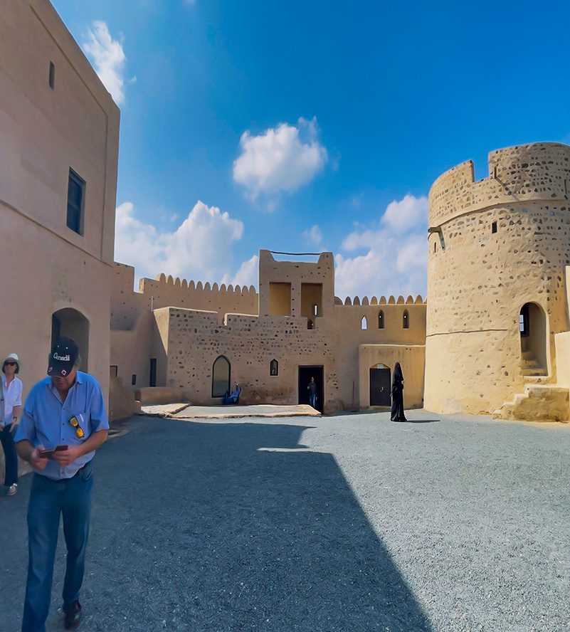 A cozy living room with a comfortable couch, a wooden table, and a patterned rug Fujairah-