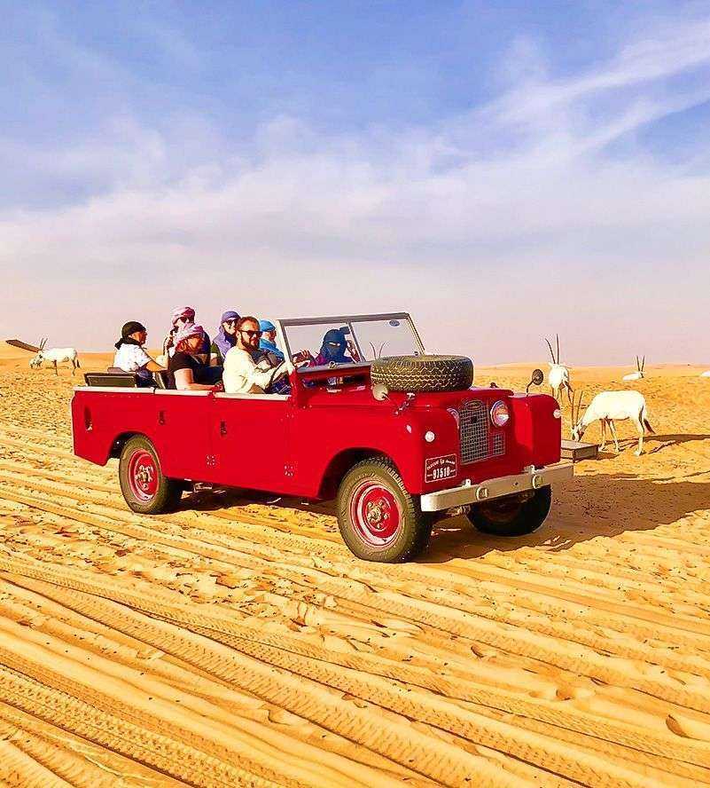 A group of people enjoying a ride in a vibrant red truck Dubai