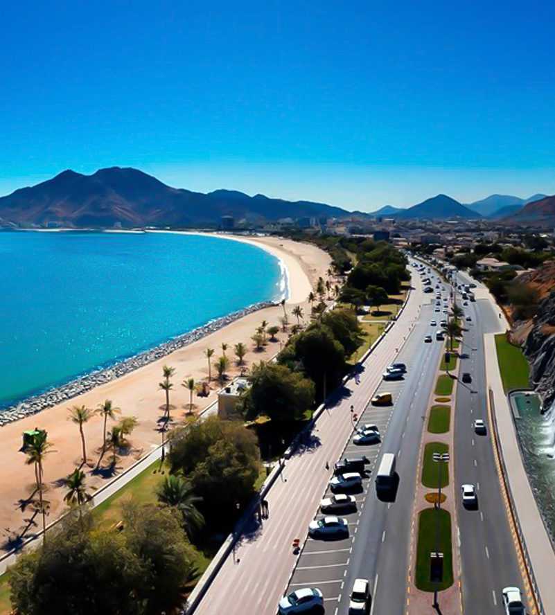 Khorfakkan Corniche und Strand: klares Wasser, goldener Sand und imposante Berge im Hintergrund