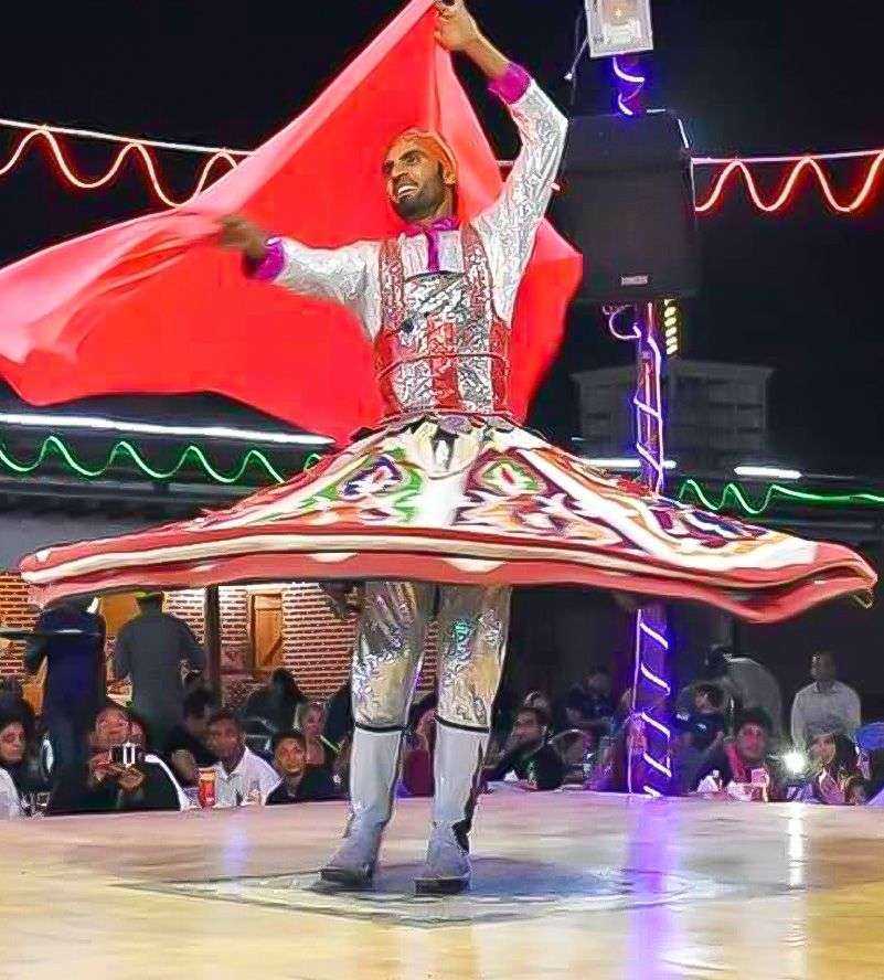 A man in a vibrant costume gracefully performs a dance Dubai