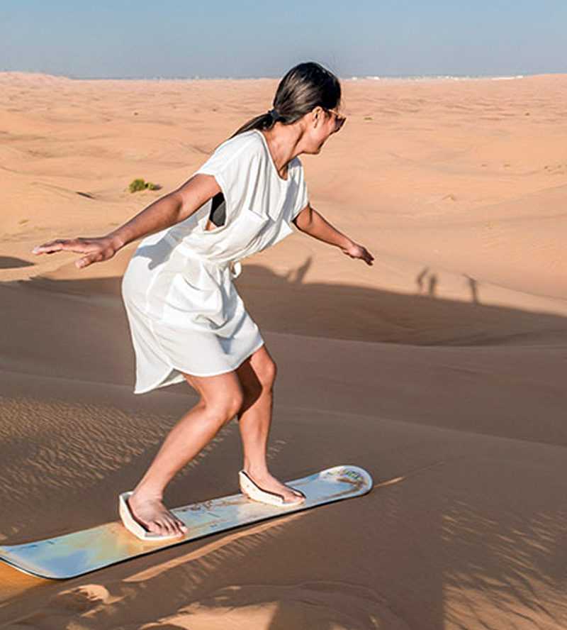 A man skillfully rides a skateboard on the sandy terrain-Dubai desert copy