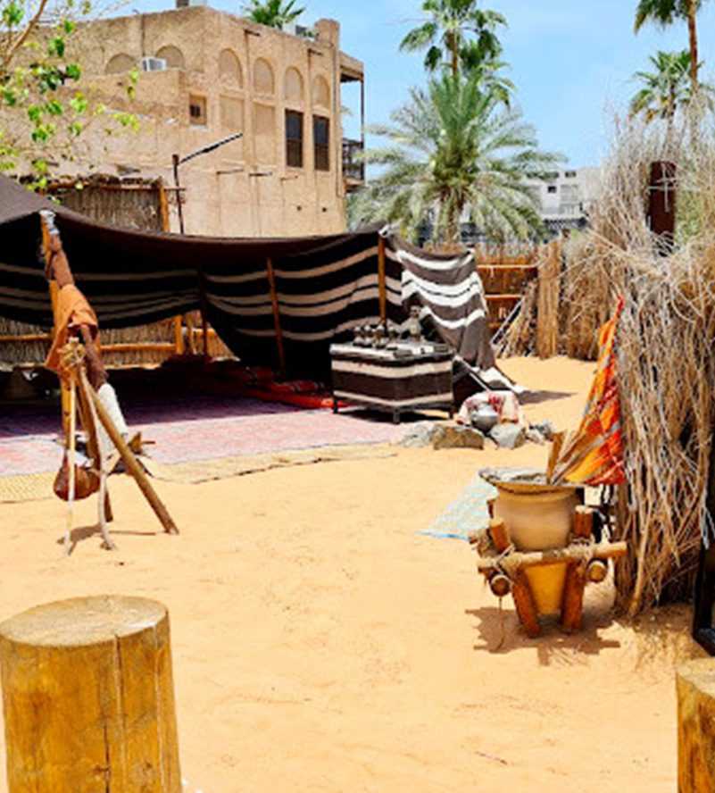 A tent with a wooden pole and table set up inside-Dubai Sightseeing Tour