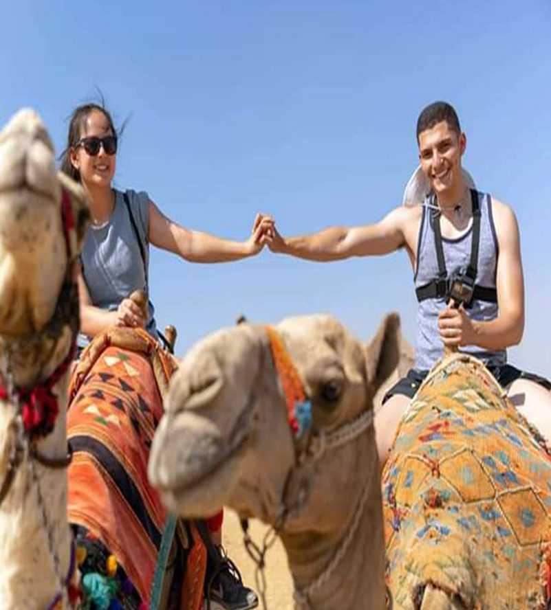 A woman silhouetted against the sun, extending her hand Dubai desert