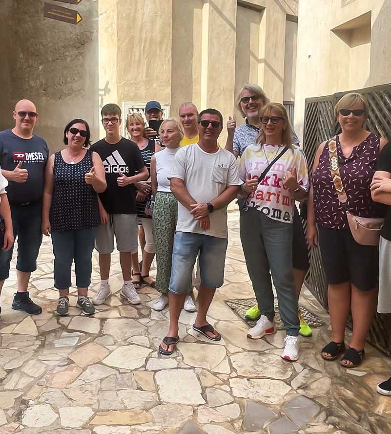 Dubai Gold Souk Group of people posing for picture in front of building-