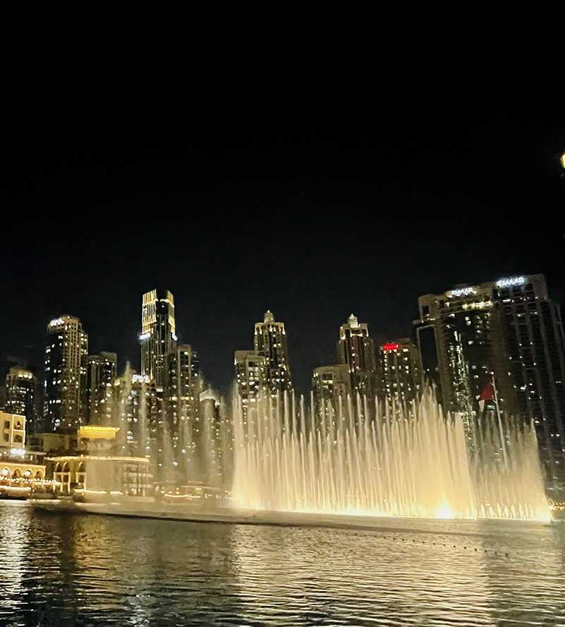 Nighttime fountain viewing with building backdrop and spectators Dubai C