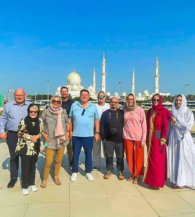 People posing for photo in front of Sheikh Zayed Grand Mosque