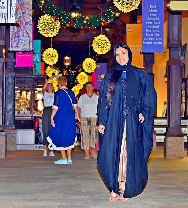 Woman in black dress walking on street Dubai