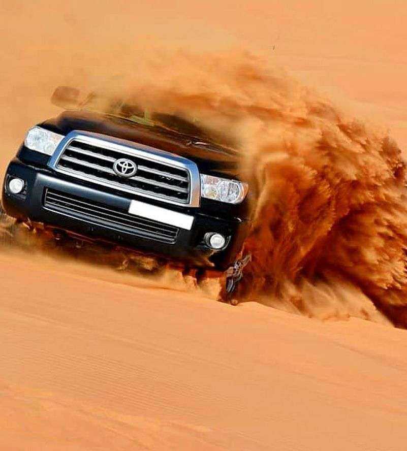 a car driving through a sand dune dubai