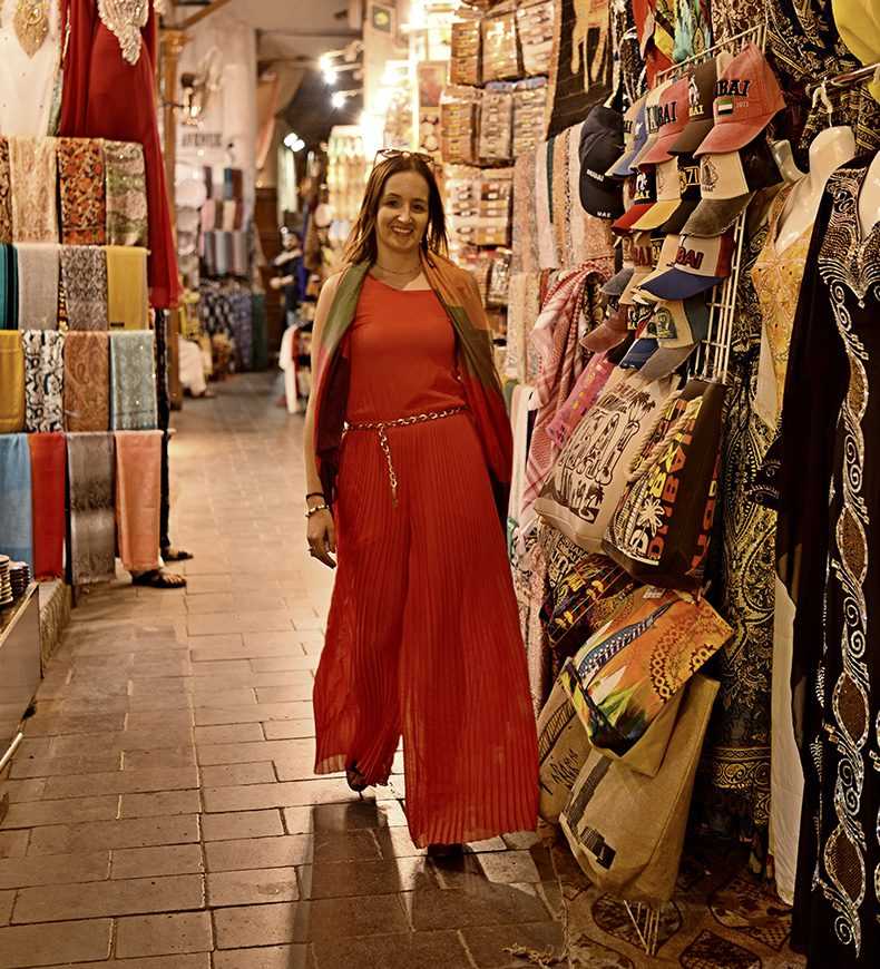 a person standing in front of a display of food Duabi at night-