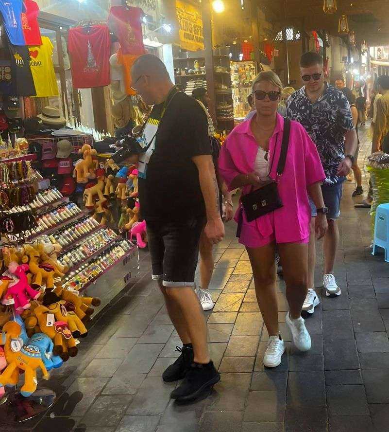group of people walking in a market Duabi at night