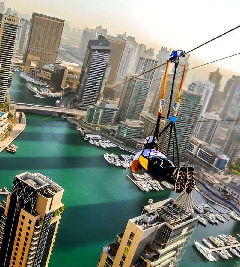 person on a zip line above a Dubai Marina