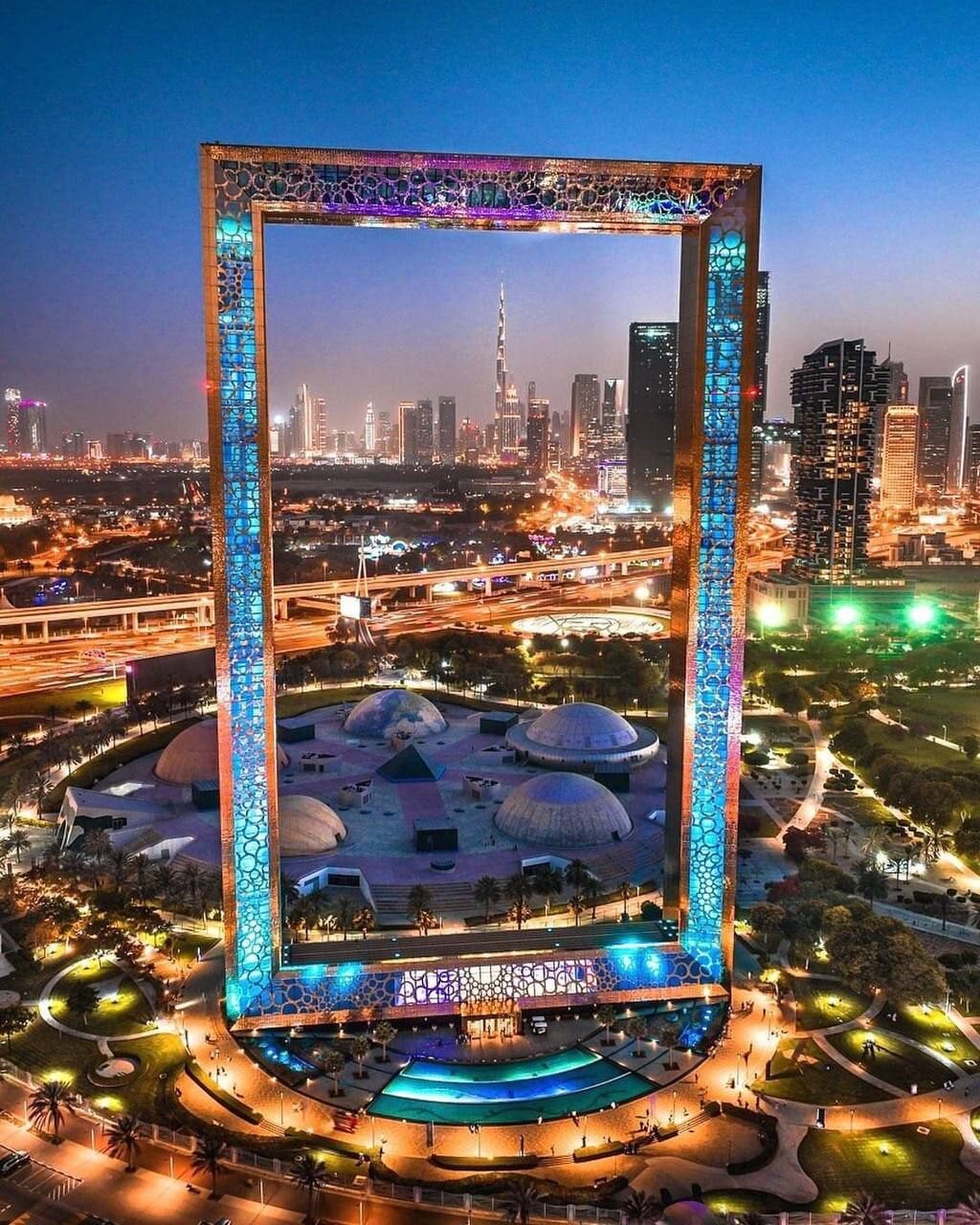 Blick durch den goldenen Dubai Frame auf das moderne Dubai – beleuchtete Skyline und pulsierendes Nachtleben, beliebtes Touristenziel und Fotomotiv in den VAE.