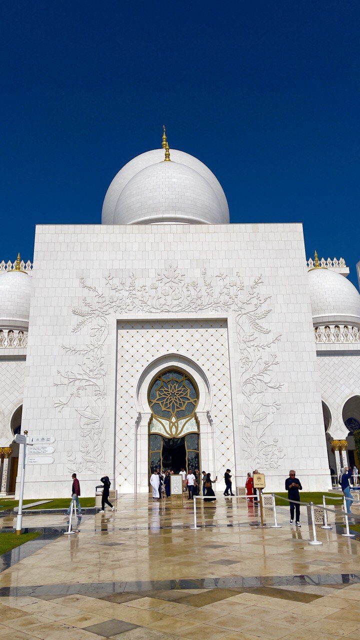 Der Haupteingang der Scheich-Zayid-Moschee besteht aus weißem Marmor und ist mit eleganten blauen Mustern kunstvoll verziert.