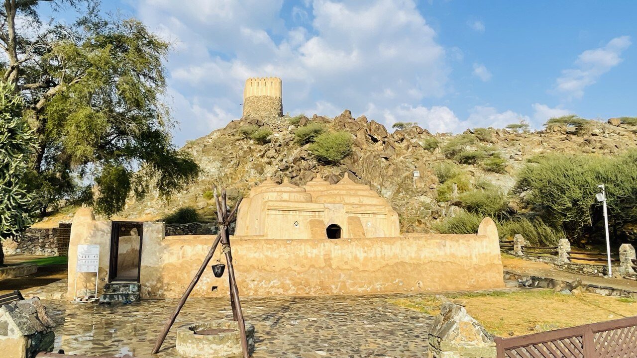 Al-Badiyah-Moschee und Wachturm – Blick auf Dattelpalmen-Farmen, Grundwasserquellen und die Hadschar-Berge in Fujairah, VAE, beliebtes historisches und touristisches Ziel.