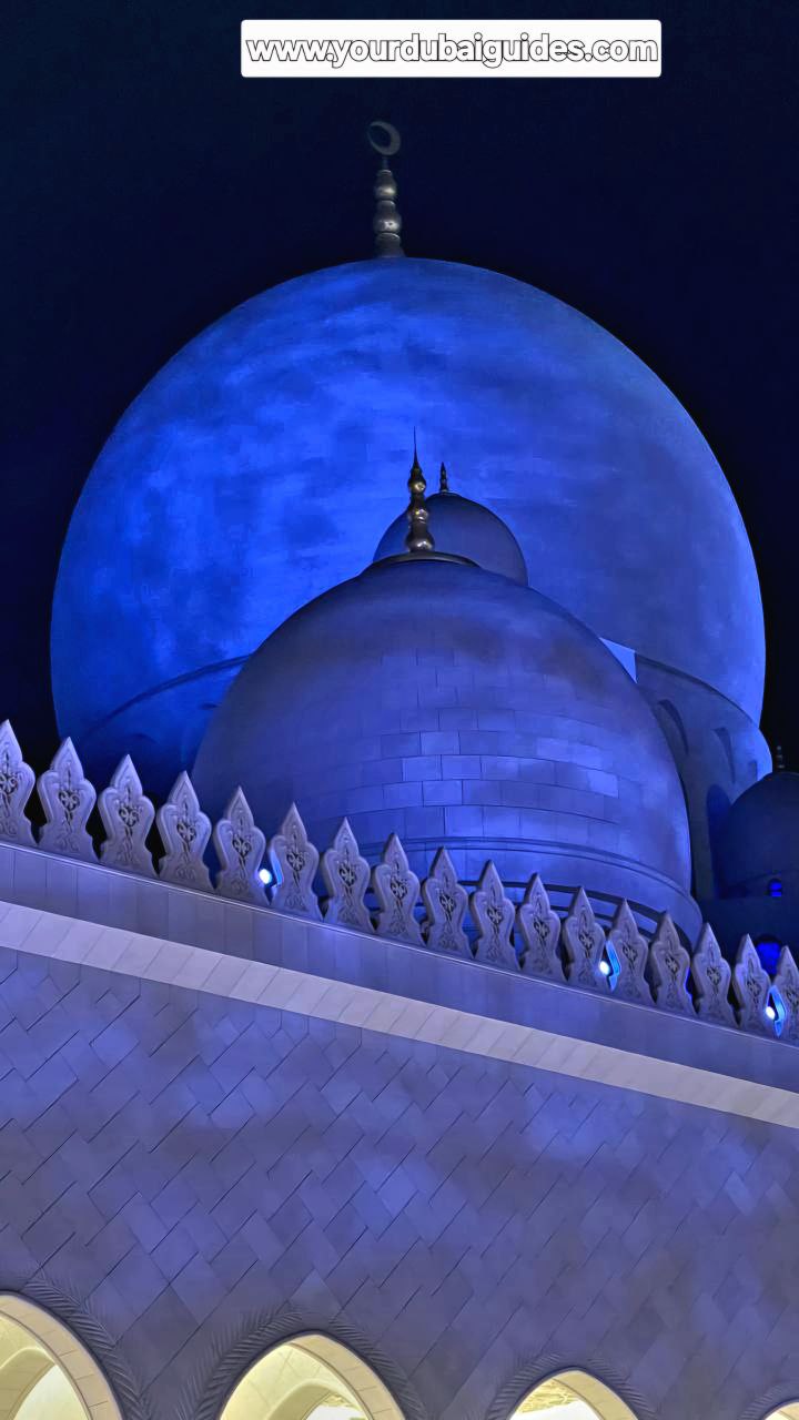 Sanfte wellenförmige Wolken in bläulicher Farbe werden auf die weißen Marmoraußenwände der Moschee, einschließlich der Fassade und der Kuppeln, projiziert.