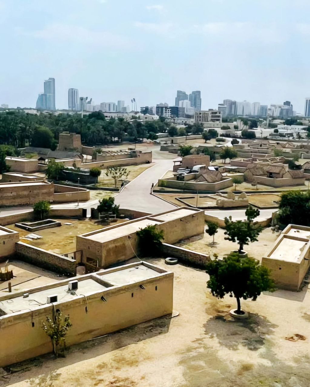 Fujairah Heritage Village – historische Lehmhäuser vor moderner Skyline