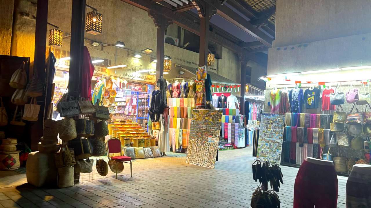 „Der Eingang zum Stoffmarkt in Bur Dubai führt in den ältesten Souq Dubais, bekannt für seine traditionellen Geschäfte mit Stoffen, Kleidung und Souvenirs.“