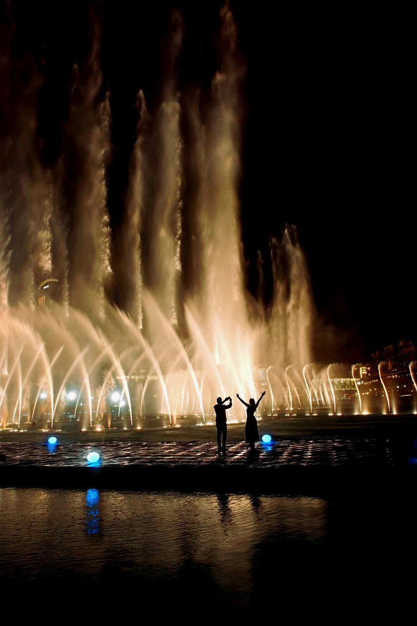 „Die Dubai Fountain ist eine der größten tanzenden Fontänen der Welt. Sie befindet sich im künstlichen Burj-See am Fuße des Burj Khalifa, direkt neben der Dubai Mall, und begeistert Besucher mit spektakulären Wasser-, Licht- und Musikshows.“
