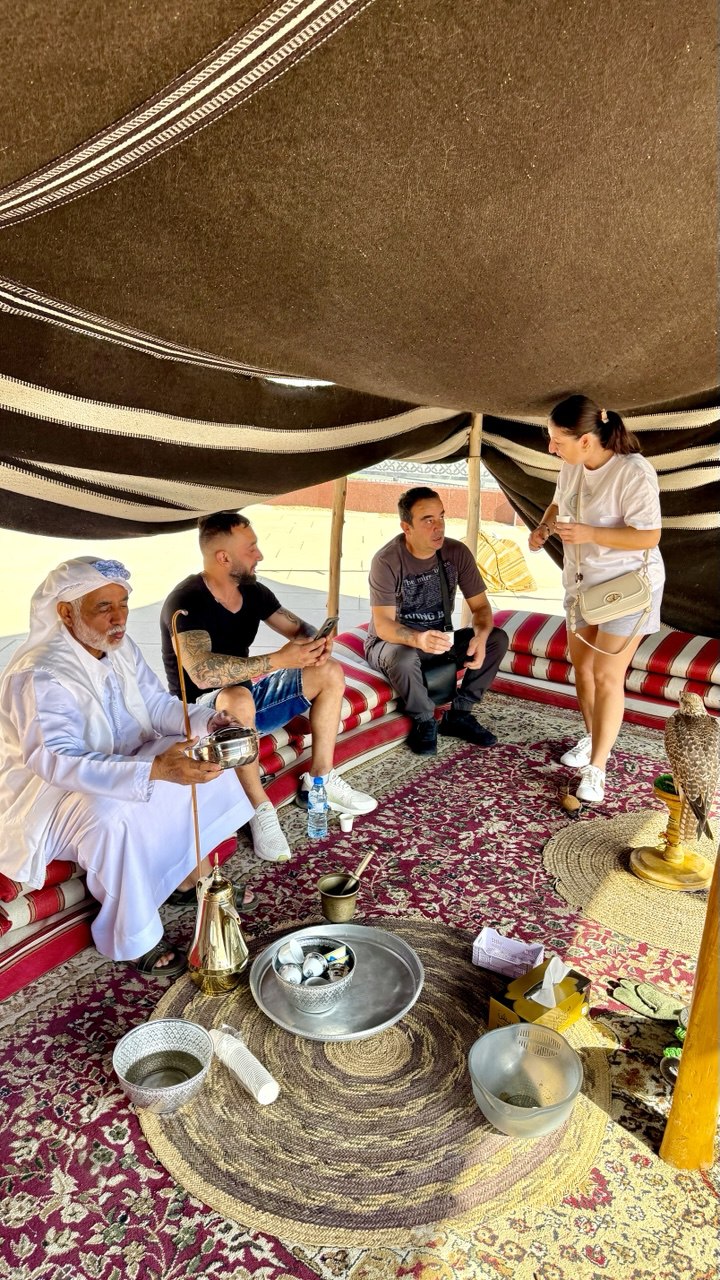„In einem traditionellen Zelt genießen Gäste arabischen Kaffee (Gahwa) und Datteln als Zeichen der emiratischen Gastfreundschaft.“