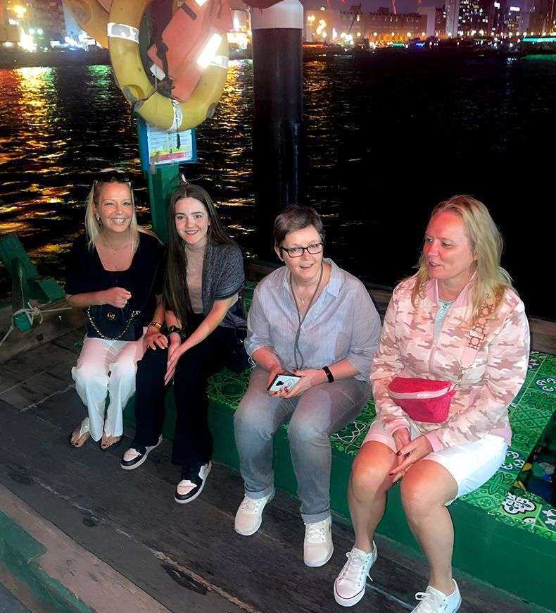 women sitting on a bench Duabi at night